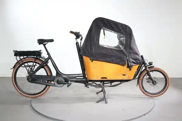 Vogue Carry 2 elektrische bakfiets met de accu op de achterdrager, zwart frame en bruine bak